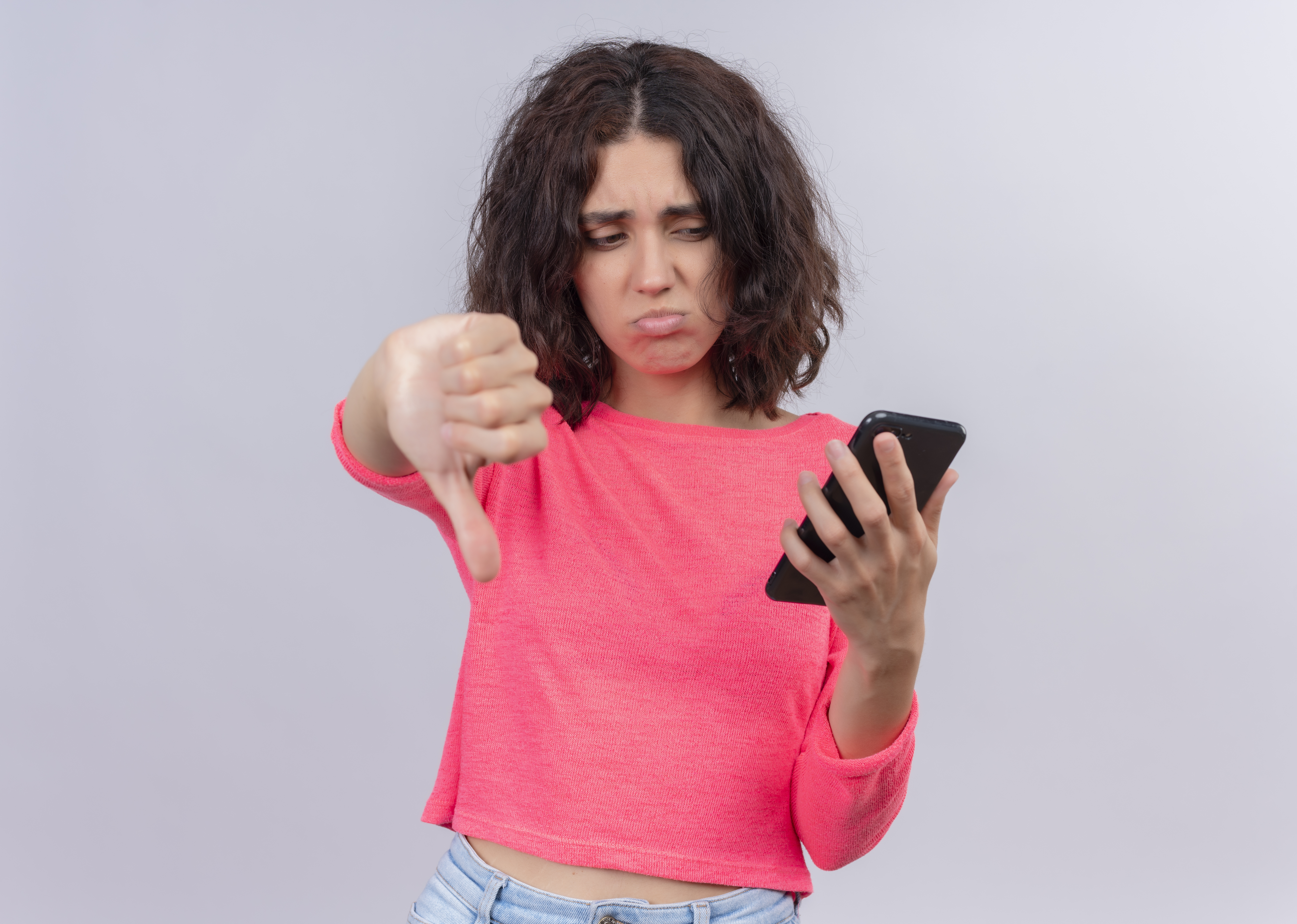 Mulher segurando um celular com expressão de decepcionada